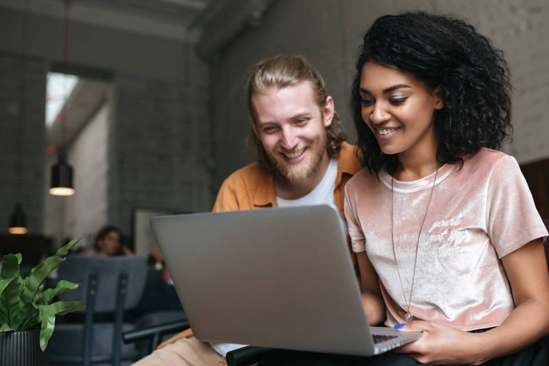 happy African-American woman working on laptop |  businesses opportunities in Canada